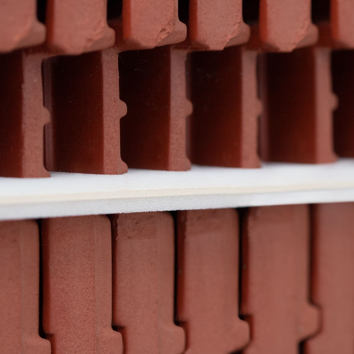 Industrieverpackungen Dachziegel auf Palette mit Zwischenlagen aus Vollpappe mit Schaumstoff kaschiert Detailansicht Kante
